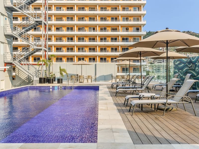 Outdoor pool area with sunbeds at One Hotels