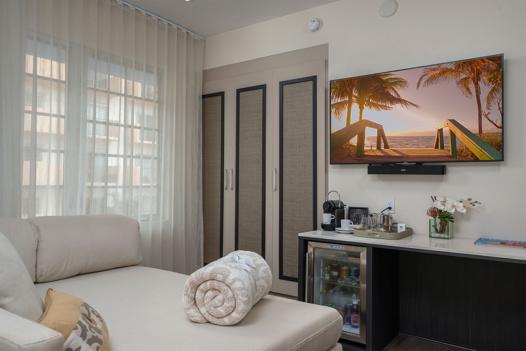 A suite with a sofa bed, TV, mini fridge, and coffee maker