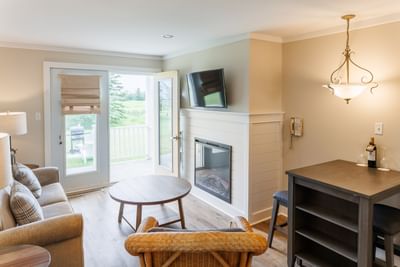 Bright living space with fireplace, sofa, and patio door in one-bedroom PEI cottages at Rodd Crowbush Golf & Beach Resor