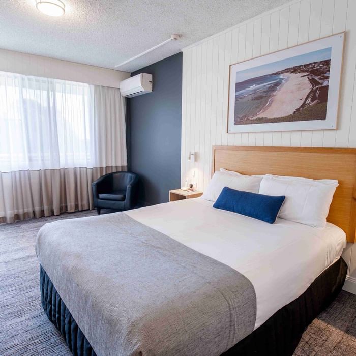 Comfortable bed and beach artwork in Mercure Charlestown room.