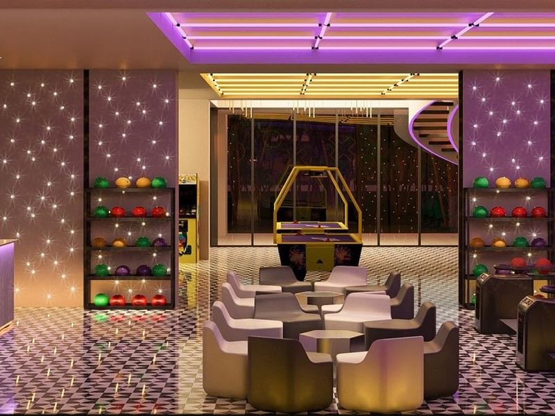 Asientos lounge chic cerca de la bolera en Fiesta Americana Funeeq Punta Cana con iluminación de neón