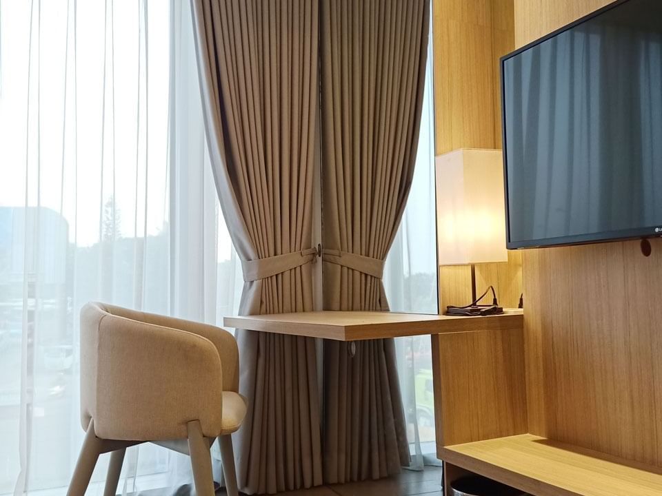 TV and seating area in King Bed Deluxe Room in LK Cikarang Hotel & Residences