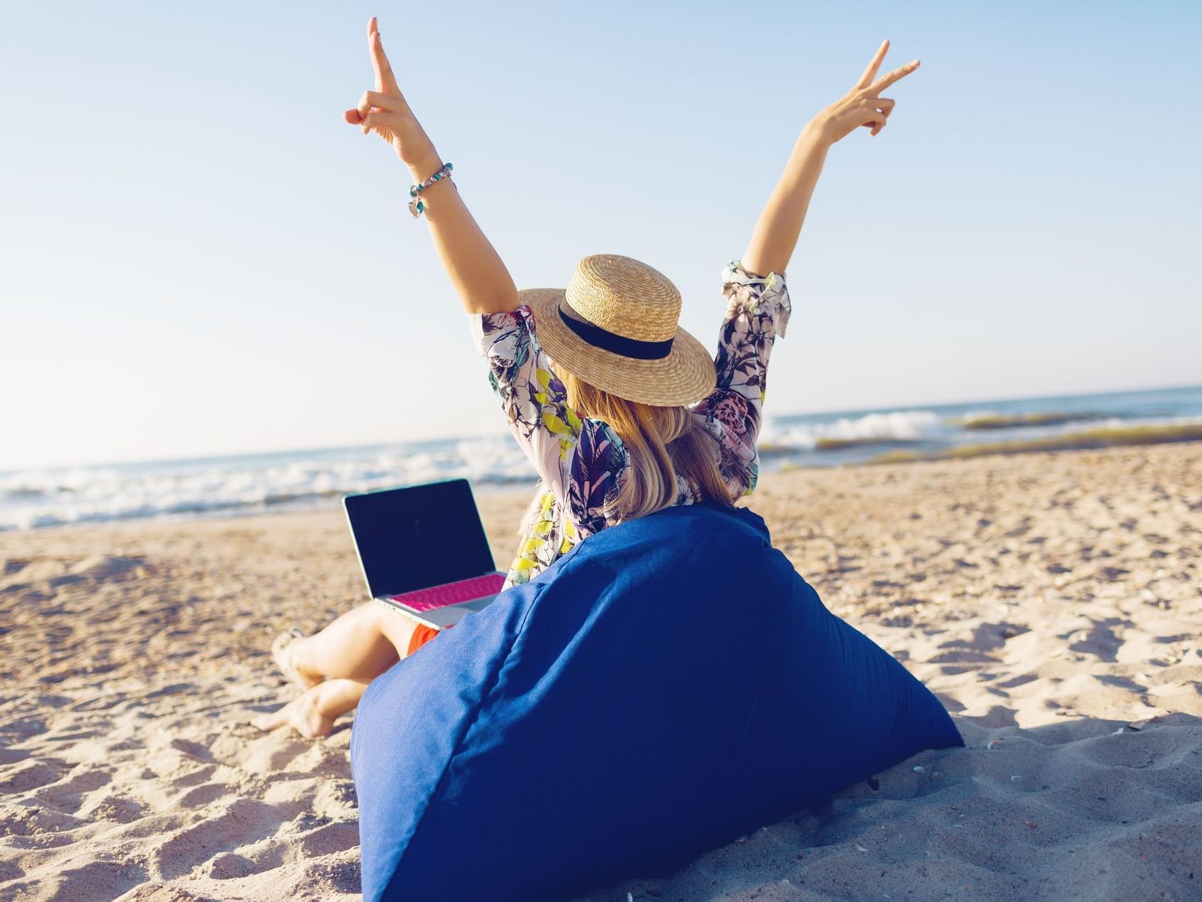 Woman with laptop on beach bean bag near Bougainvillea Barbados