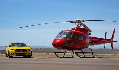 A helicopter and a car parked near Freycinet Lodge