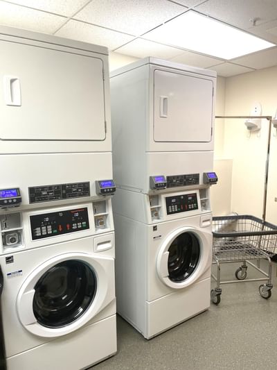 A laundry room with a row of washers and dryers at Boothill Inn & Suites