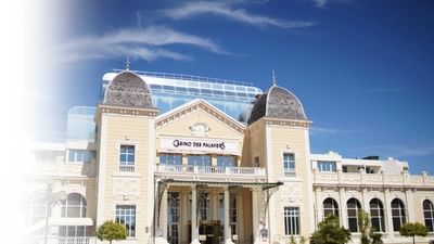 Escapade Business au Bar du Pasino affichant un bâtiment avec des palmiers et un ciel bleu