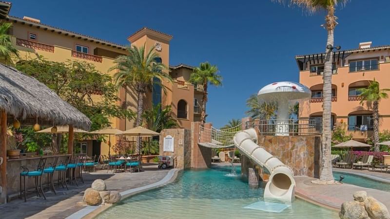 Alberca infantil Las Fuentes con tobogán, fuente con forma de hongo y edificios del resort en Hacienda del Mar Los Cabos.