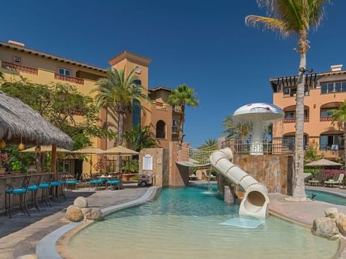Alberca infantil Las Fuentes con tobogán, fuente con forma de hongo y edificios del resort en Hacienda del Mar Los Cabos.