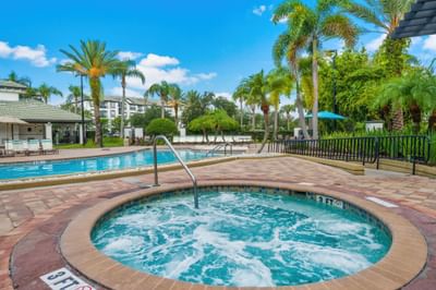 Hot tub with pool and palm trees at Vista Cay Resort By Millenium