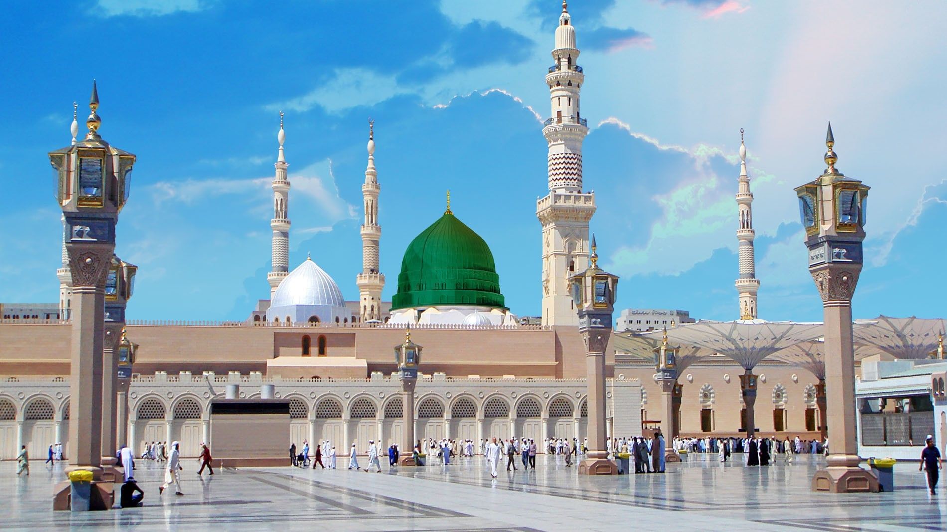 The iconic Green Dome and white minarets of Al-Masjid an-Nabawi under a bright blue sky at Saja Warwick Madinah
