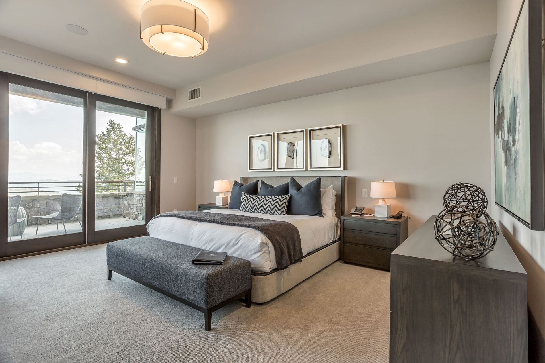 Bedroom with a king bed featuring large windows & interior at Stein Eriksen Residences