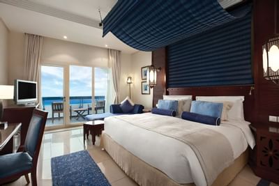 Large bed, King Deluxe room with sea view at Ajman Hotel