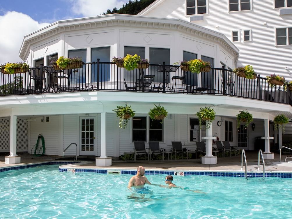 Outdoor heated pool with family in it 