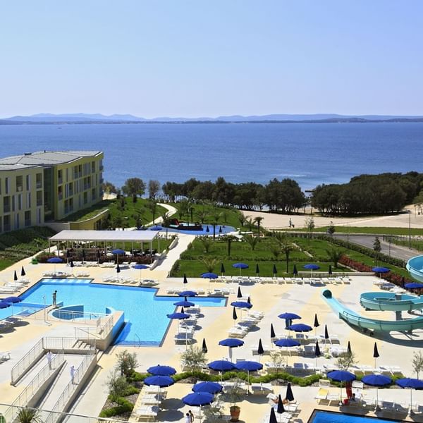 Aerial view of outdoor pool & sunbeds at Falkensteiner Hotels