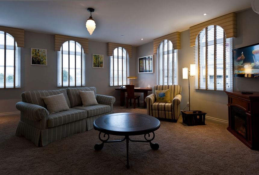 Living area with cozy sofa, TV & workspace in Apartment 202 at Retro Suites Hotel