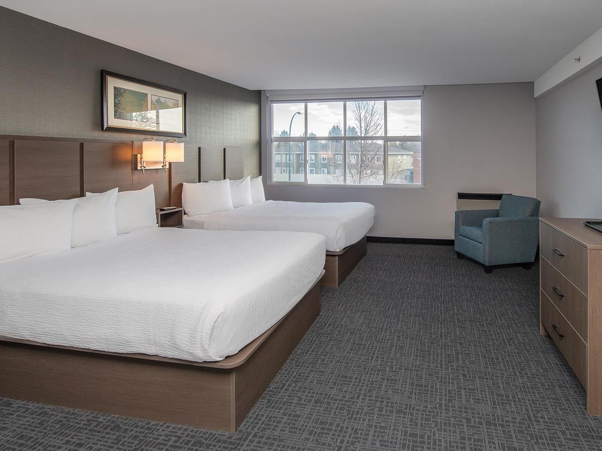Two queen beds with white linens and sofa bed.