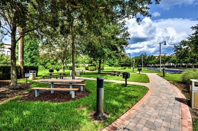 Brick pathway and picnic tables in a park area at Vista Cay Resort By Millenium