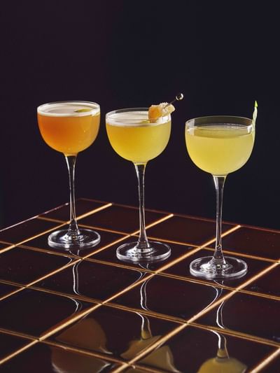 Three glasses of cocktails with garnishes at Sofitel Sydney Wentworth in Sydney.