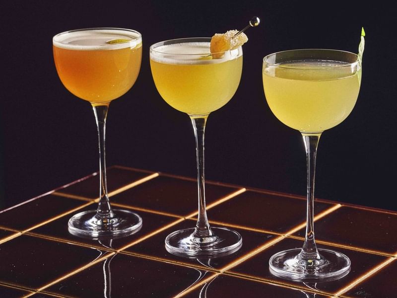 Three glasses of cocktails with garnishes at Sofitel Sydney Wentworth in Sydney.