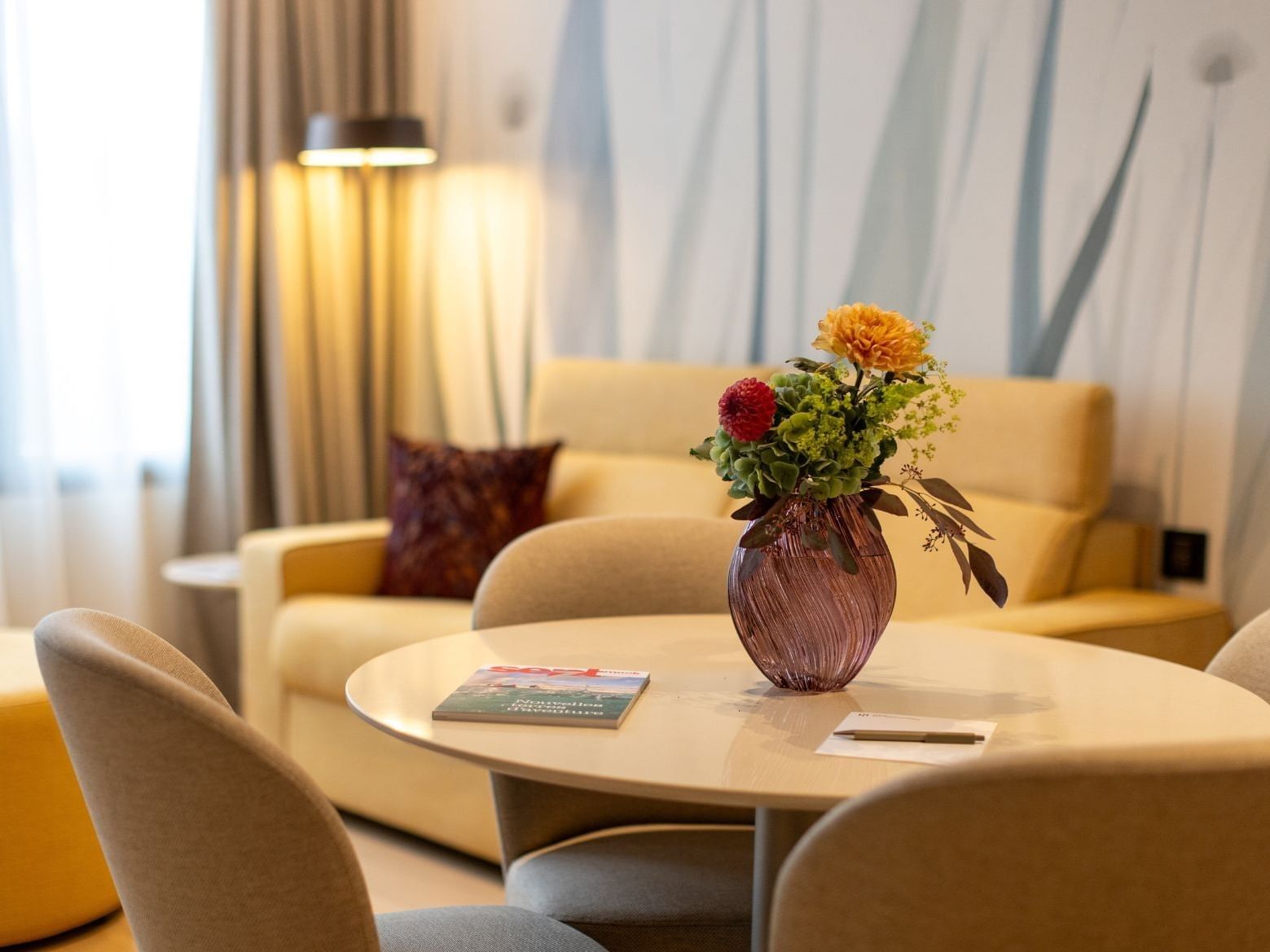 Detailed view of 2-rooms apartment / Family stay at Hotel des Innovations with a flower vase on a table and a yellow sofa