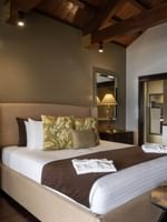 Large bed with pen-plan bathroom includes a white vessel sink & mirror in Erakor Residence at warwick le lagon-vanuatu