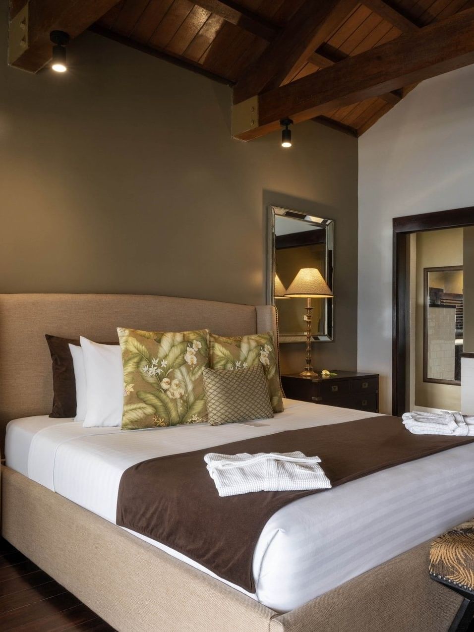 Large bed with pen-plan bathroom includes a white vessel sink & mirror in Erakor Residence at warwick le lagon-vanuatu