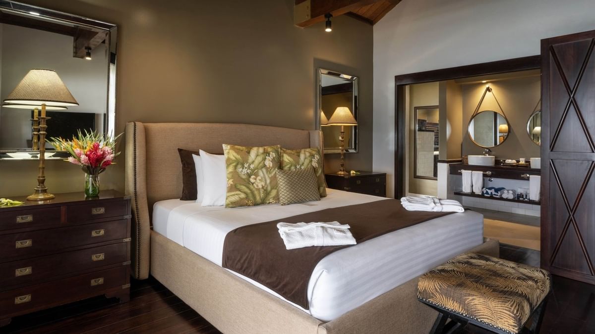 Large bed with pen-plan bathroom includes a white vessel sink & mirror in Erakor Residence at warwick le lagon-vanuatu