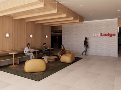 People relax in a modern, wooden-paneled lobby with seating area at UniLodge.