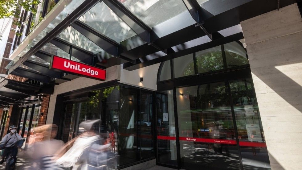 Blurry pedestrians pass by UniLodge Melbourne Central on La Trobe Street.