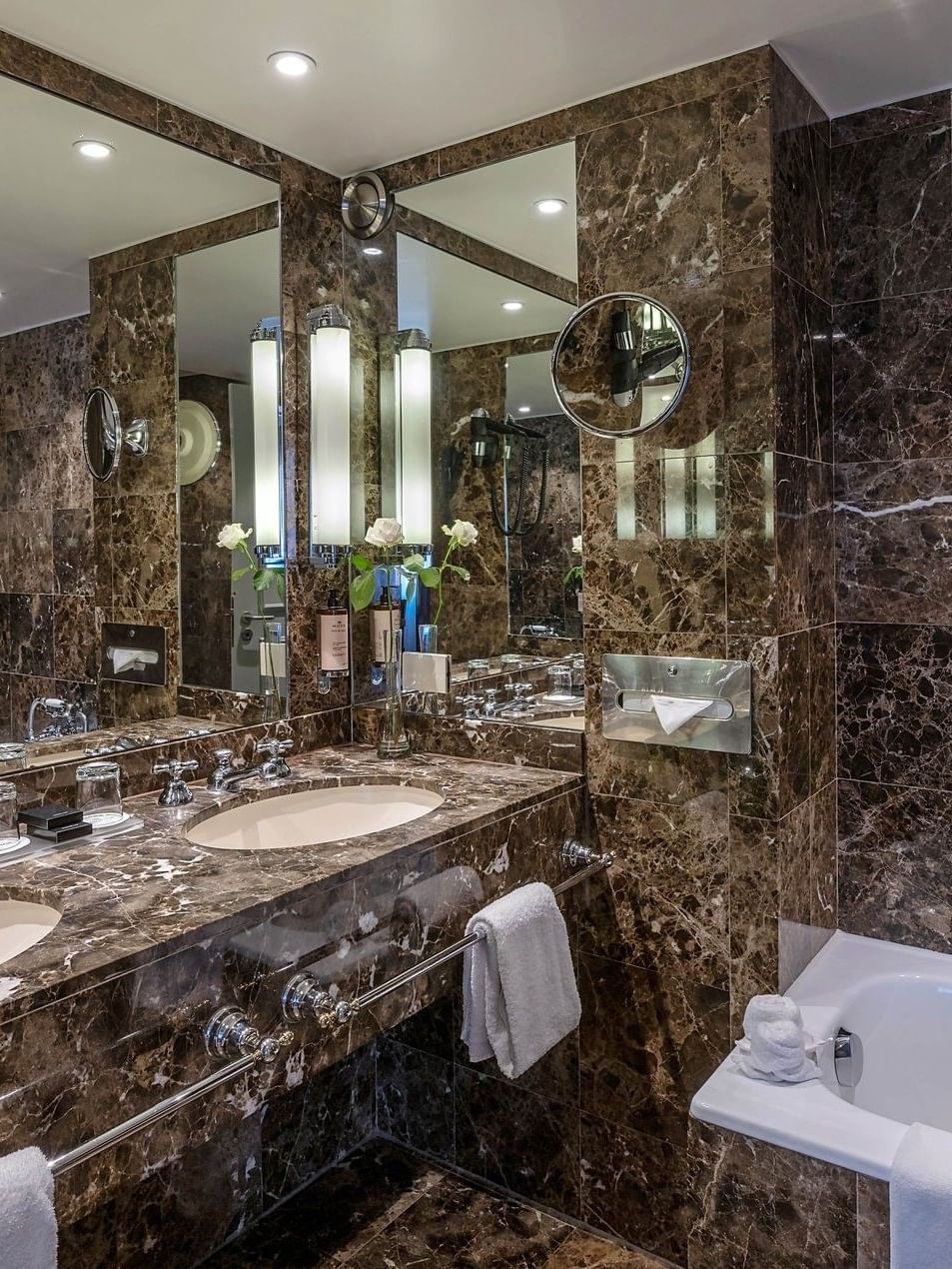 Marble vanity with mirrors by the bathtub in Warwick Suite at Warwick Grand Place Brussels