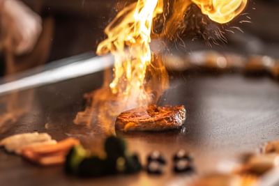 Close-up of a sizzling meat on the stove at Hanoi Daewoo Hotel
