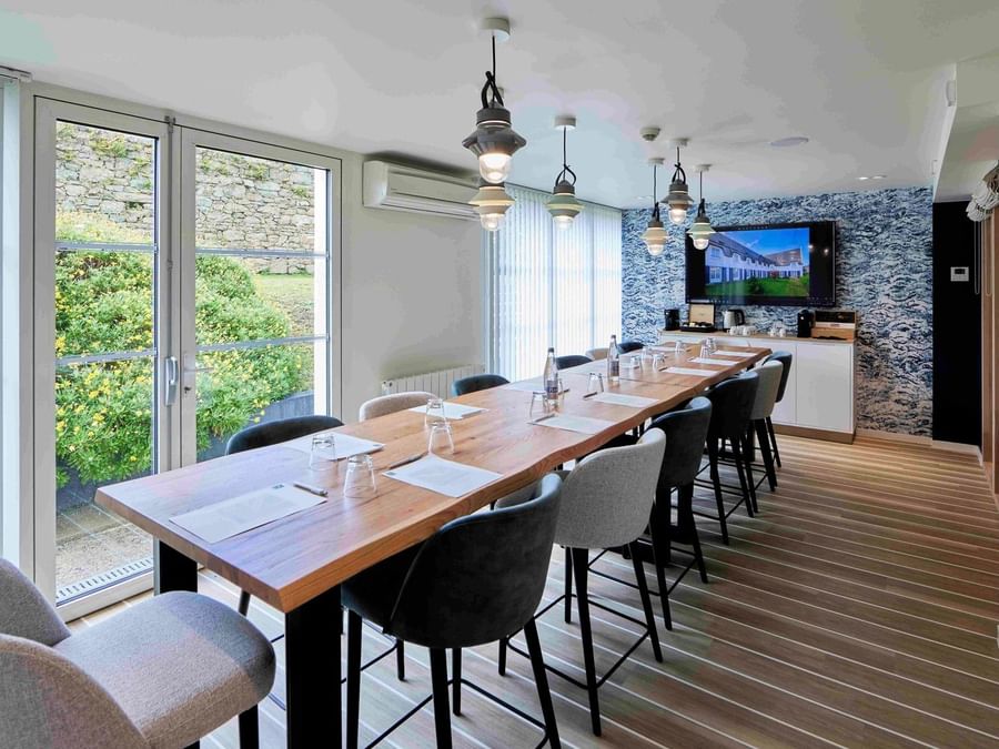 Salle de réunion élégante avec table en bois et chaises à l'Hôtel La Marébaudière.