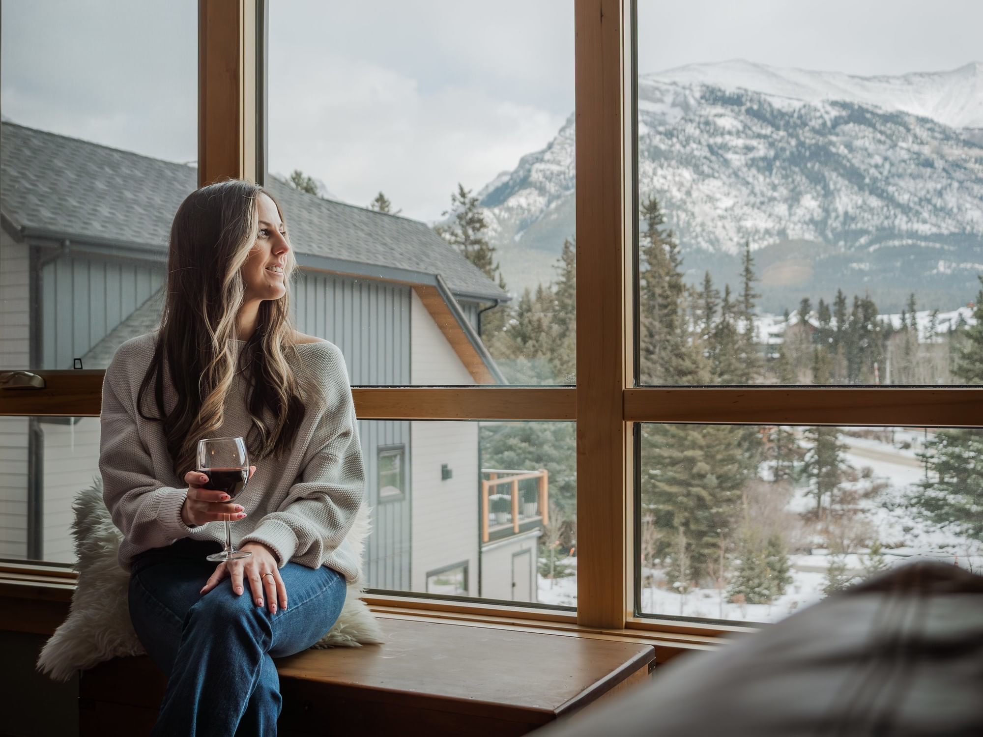 Woman in front of large Spring Creek Vacations condo window with mountain view.