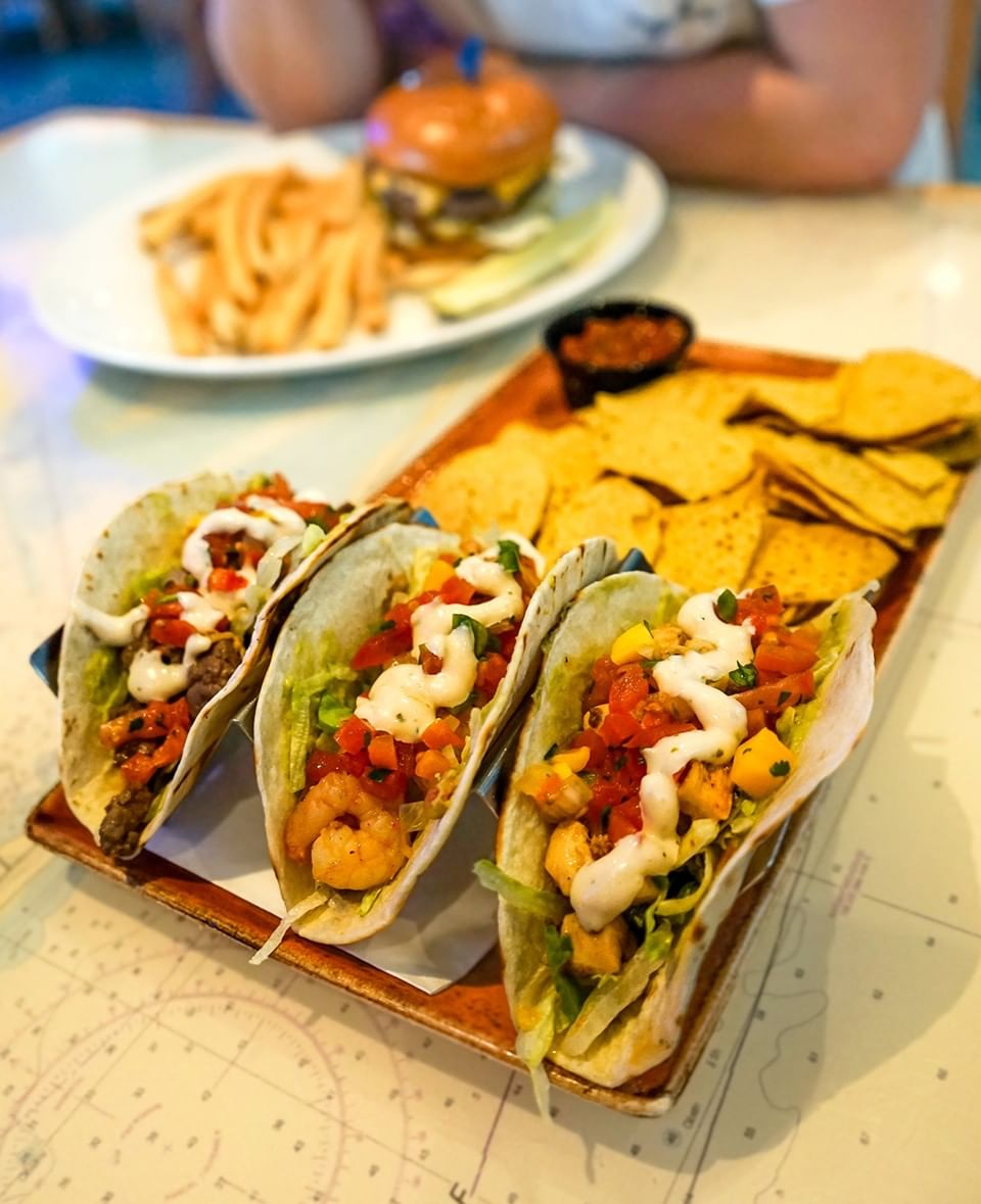 Delicious fish tacos and chips served on a tray over a nautical map table at Margaritaville Resort Biloxi