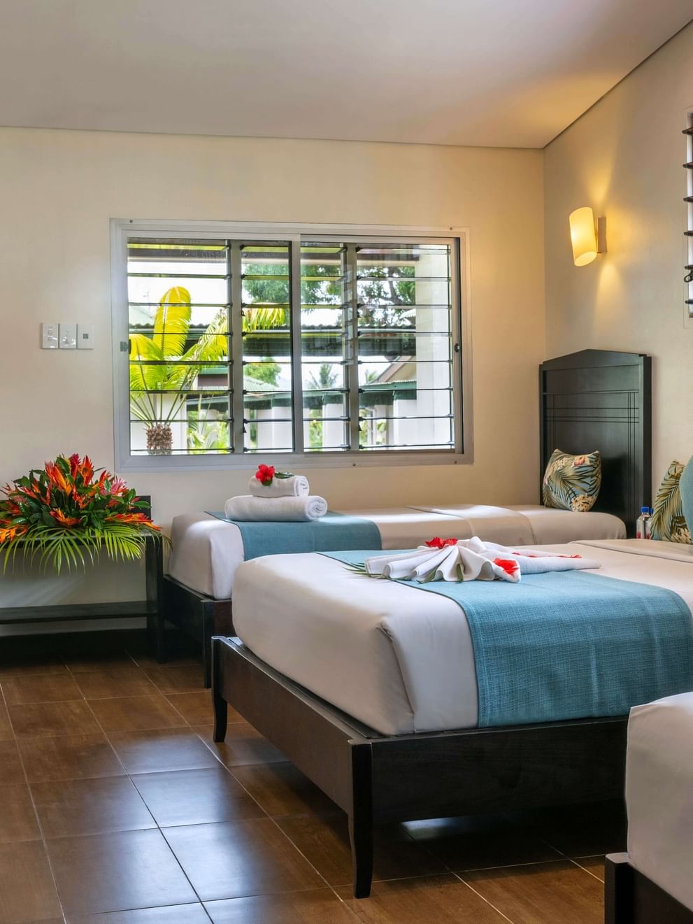 Comfortable Family Villa with multiple beds, tropical decor, and scenic window views at Tokatoka Resort in Nadi.
