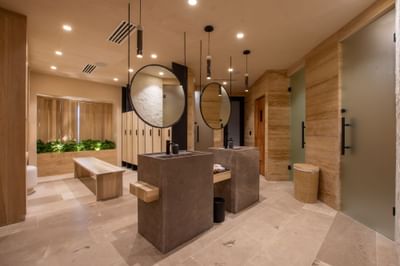 Bathroom interior with stone sinks, mirrors, bench, and indoor plants at Villa Premiere Boutique Hotel & Romantic Getaway