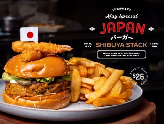 Plate with Japan special Shibuya Stack burger and fries on a wooden table.