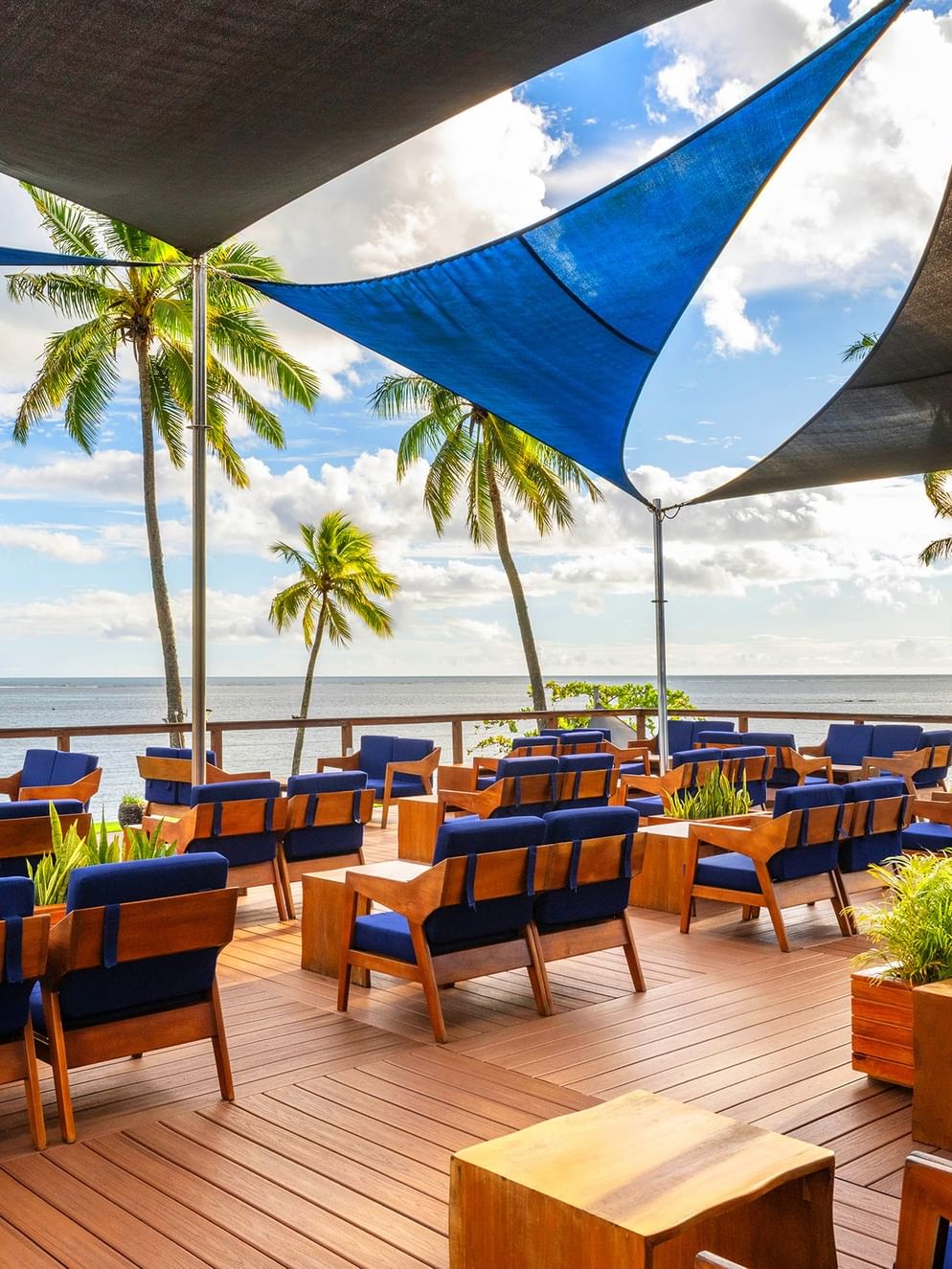 Blue and wooden seating area with ocean view at The Naviti Resort - Fiji, Korolevu.