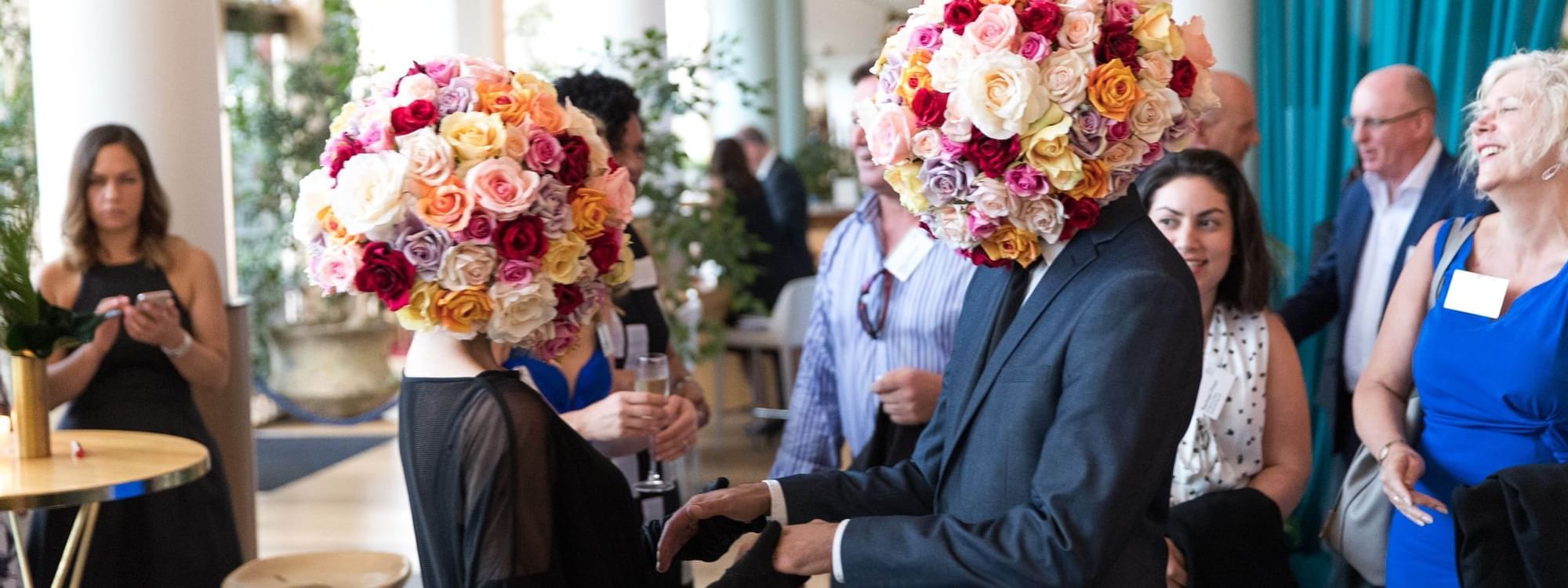 Two people with elaborate floral arrangements as heads at The Ternary in Novotel Sydney on Darling Harbour