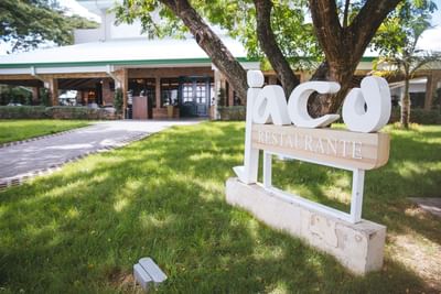 Jaco Restaurant signboard placed in the garden area at Cha Cha Hotel