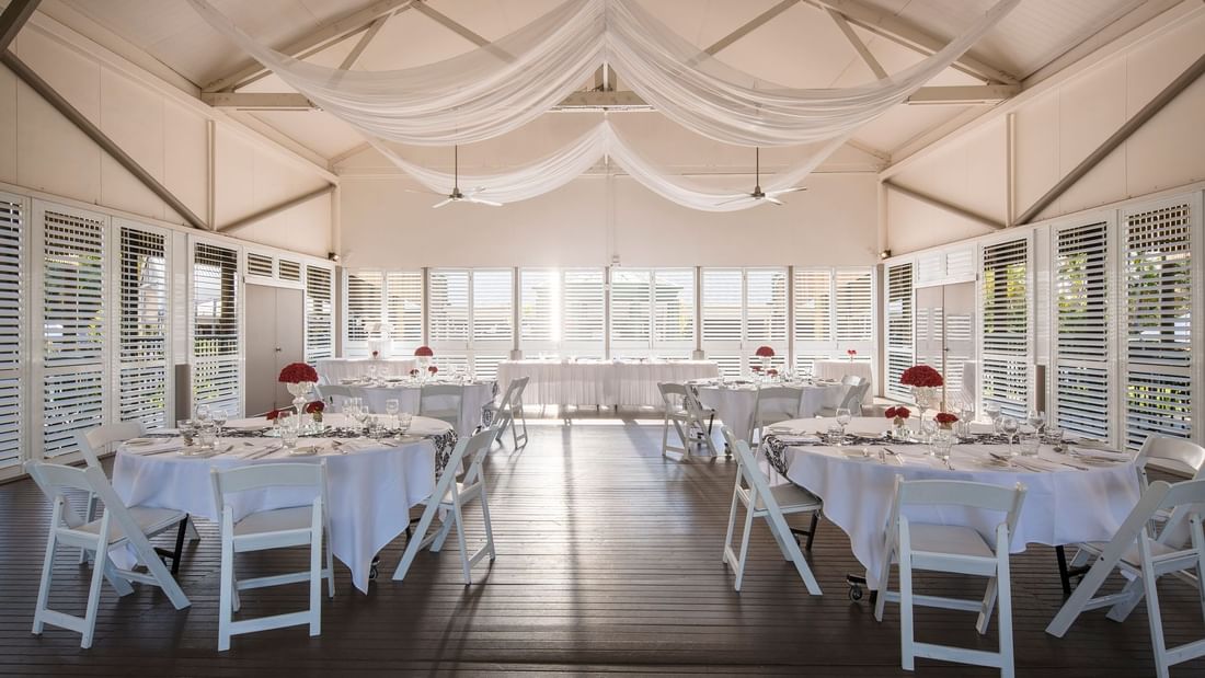 Plantation Deck featuring round tables with floral centerpieces, and sheer drapery at Mercure Hotel Townsville