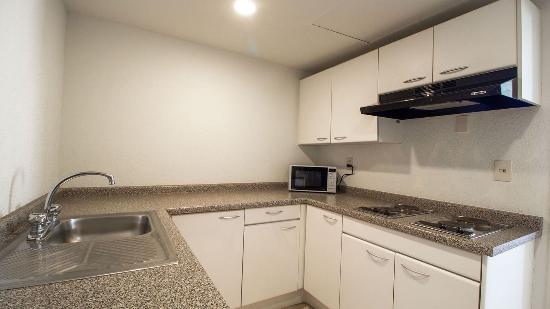 King Bed and 2 Double Beds Suite 2 Rooms kitchenette with cabinets, and a microwave at Camino Real Puebla Angelopolis