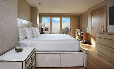 TV facing bed with side table near window in Modern Presidential Suite at The J House Greenwich