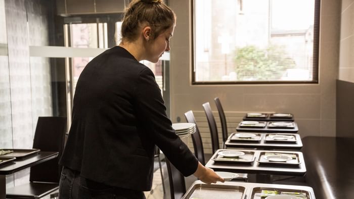 Closeup of staff arranging a table for dining at Hotel du Grand