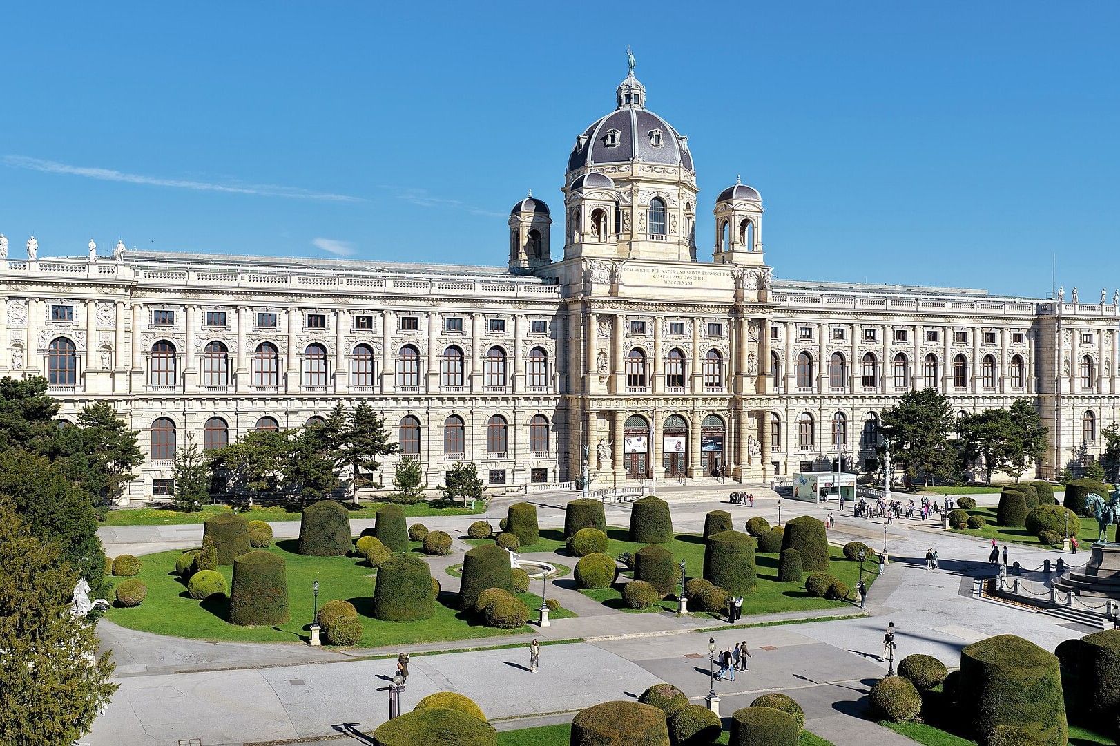 Exterior view of the Natural History Museum Vienna with its grand dome and manicured gardens at Maria Theresa Square