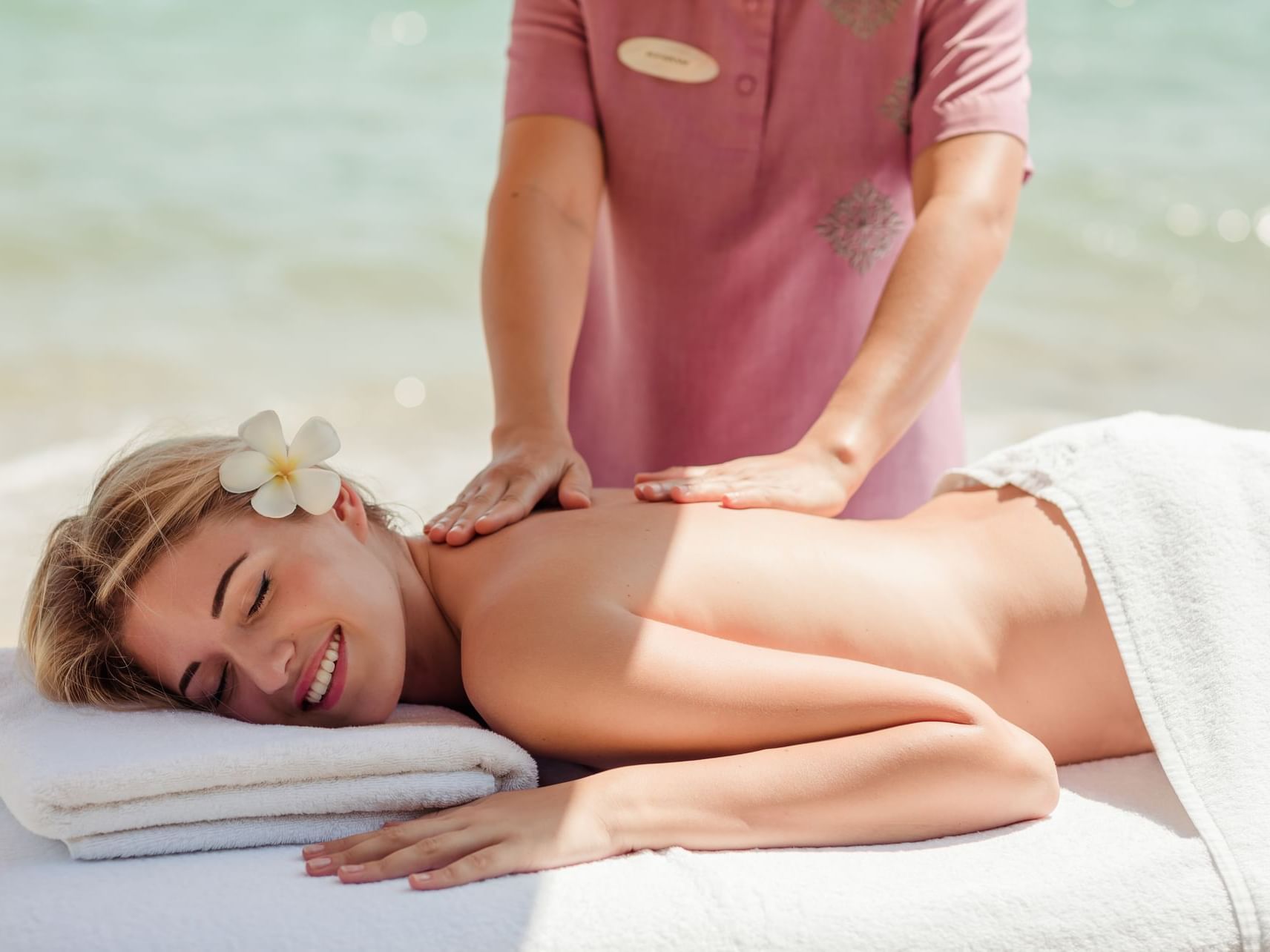 female guest having a massage by the beach