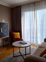 Living area with side cupboard and plush seating in the Premium Suite at Warwick Reine Astrid - Lyon