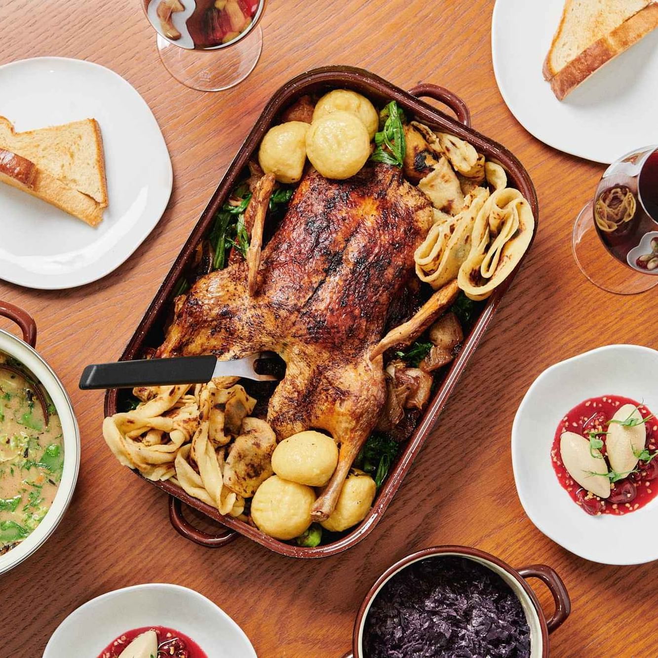 Roasted chicken with soup, bread, salad, and red wine served on a table at Almanac X Alcron Prague