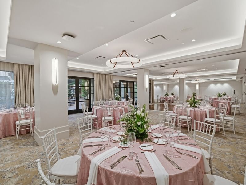 Elegantly set tables with floral centerpieces in the Courtyard Ballroom at el PRADO Hotel, Palo Alto.