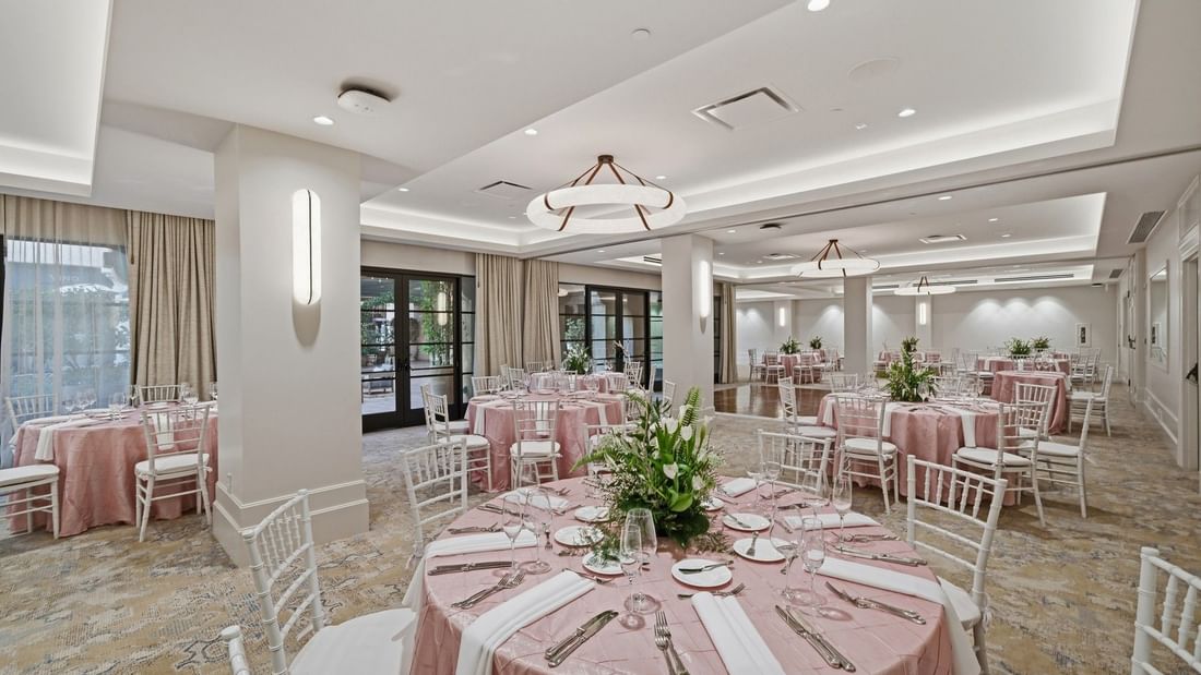 Elegantly set tables with floral centerpieces in the Courtyard Ballroom at el PRADO Hotel, Palo Alto.